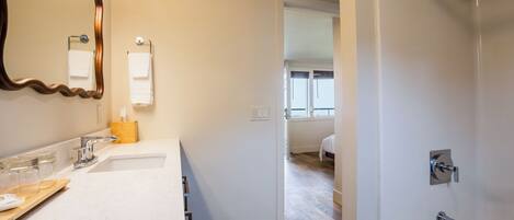 Un baño moderno con lavamanos doble, espejo, toallero y ducha.