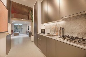 A modern kitchen with a gas stove, a microwave, and a sink. - Private Patio / Gym / Sauna / Loft / Fast Wifi (Dubai)