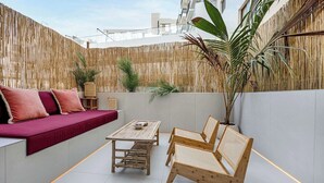 A modern outdoor seating area with a sofa, a table, and chairs. - Private Patio / Gym / Sauna / Loft / Fast Wifi (Dubai)