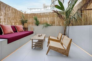 A modern outdoor seating area with a sofa, a table, and chairs. - Private Patio / Gym / Sauna / Loft / Fast Wifi (Dubai)