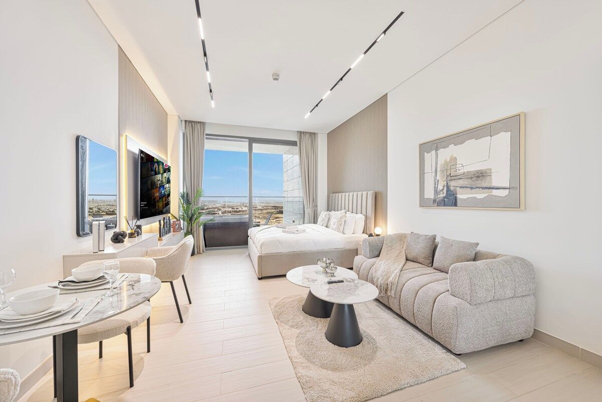 A modern living room with a sofa, a dining table, and a TV.