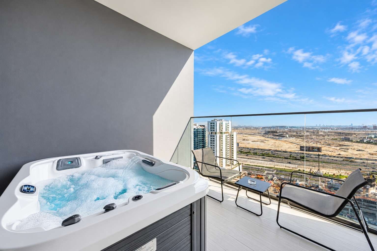Ein Balkon mit Whirlpool und Blick auf eine Stadtlandschaft.