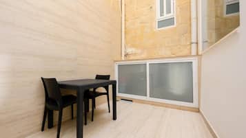 A room with a dining table and chairs, a window, and a door with frosted glass panels.