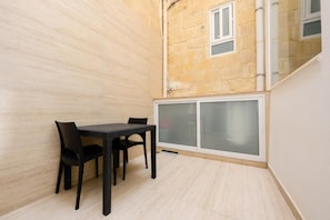 A room with a dining table and chairs, a window, and a door with frosted glass panels.