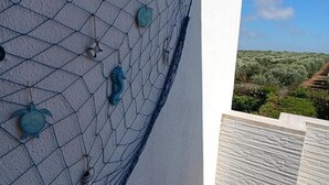 A balcony with a decorative net and wall-mounted decorations.