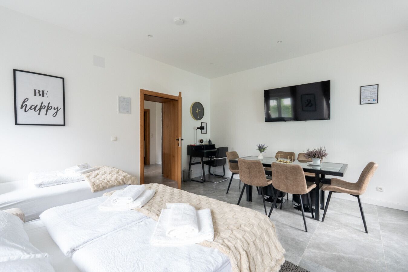 Una habitación de hotel moderna con cama, escritorio y zona de comedor.