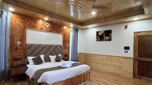 Ein Schlafzimmer mit Holzwänden, einem Bett, Nachttischen und einem Teppich.