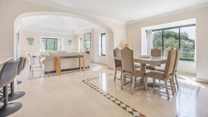 A spacious living area with a dining table, chairs, and a kitchen in the background. - Villa 'Arcos Golf Jacaranda 11' with Mountain View, Wi-Fi and Air Conditioning (Arcos de la Frontera)