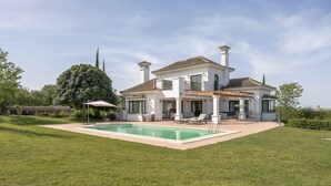 A large house with a swimming pool, a covered patio, and a well-maintained lawn. - Villa 'Arcos Golf Jacaranda 11' with Mountain View, Wi-Fi and Air Conditioning (Arcos de la Frontera)