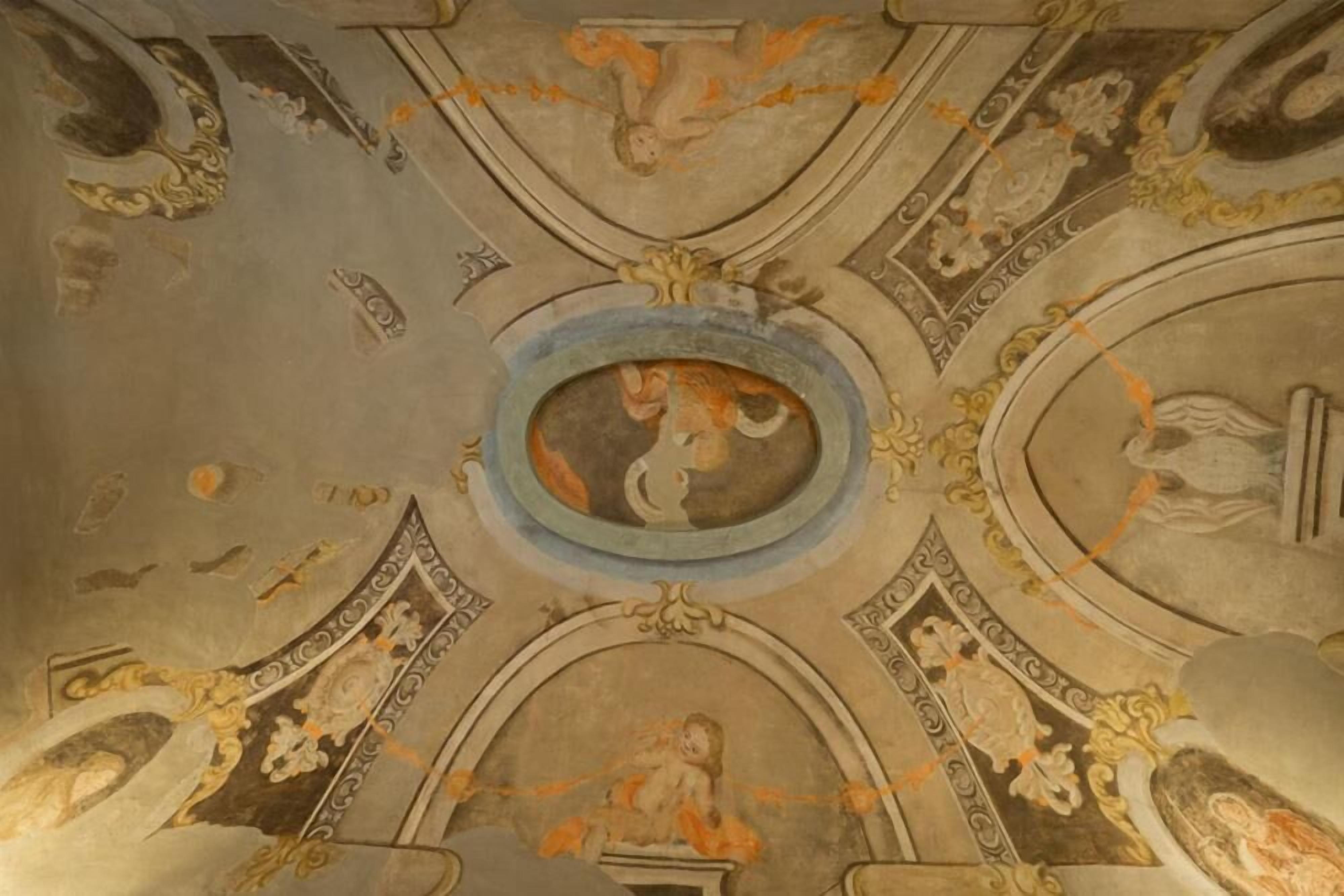 A ceiling with intricate frescoes and architectural details.