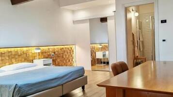 Ein modernes Schlafzimmer mit Holzboden, einem Bett, einem Esstisch aus Holz und einem Oberlicht.