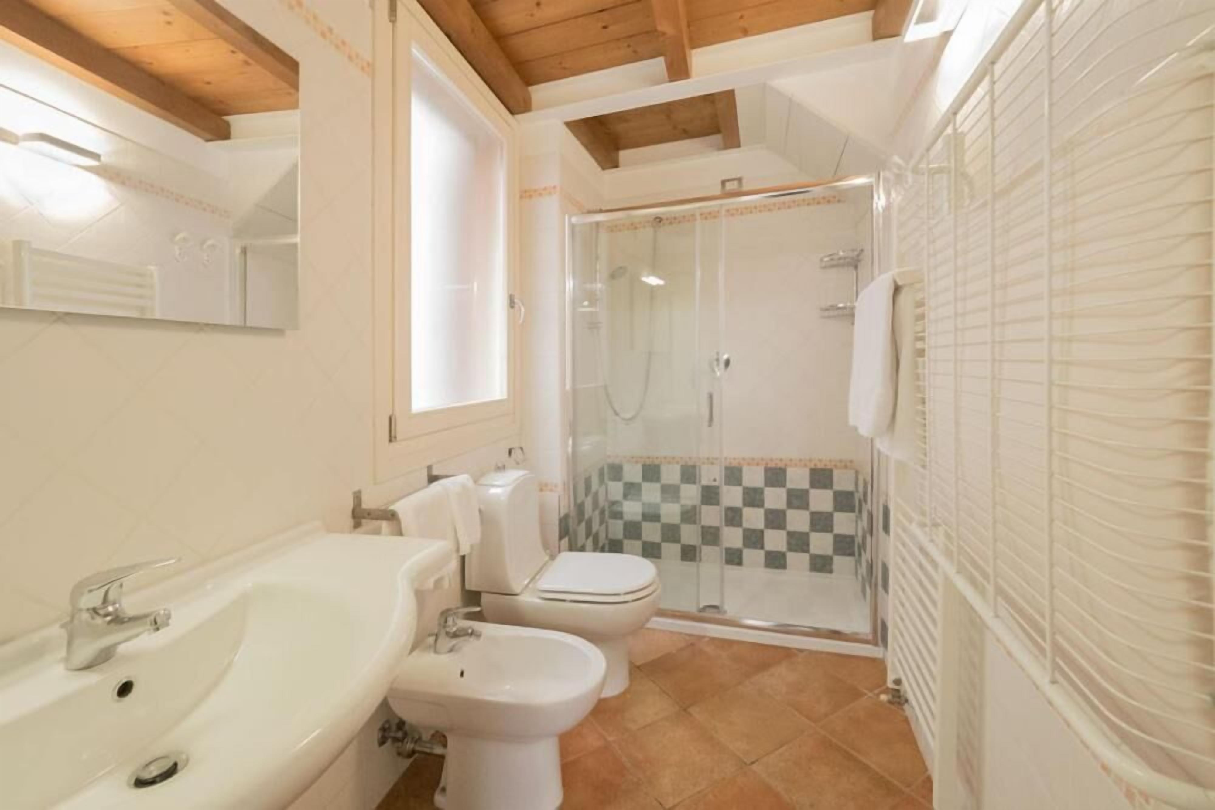 Une salle de bain équipée d’un lavabo, d’un bidet, de toilettes et d’une douche.