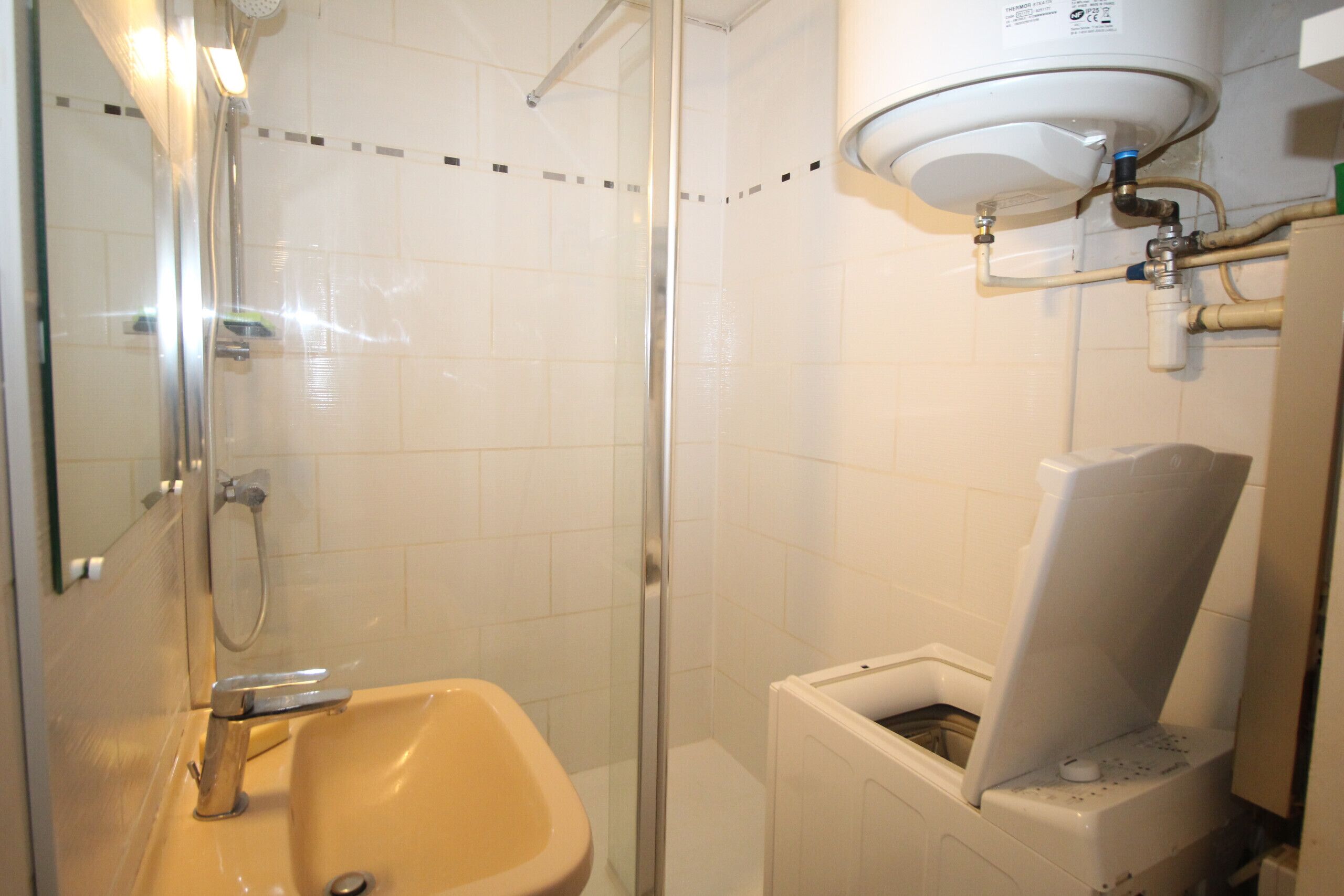 A bathroom with a glass-enclosed shower, a sink, and a toilet.