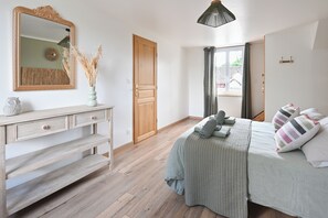 A bedroom with a bed, dresser, mirror, and a window with curtains. - "LES FOUGÈRES" Vacation Home near Baie de Somme, ideal for families (Ochancourt)