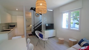Eine moderne Wohnung mit Küche, Essbereich, Wohnzimmer und einer Treppe.