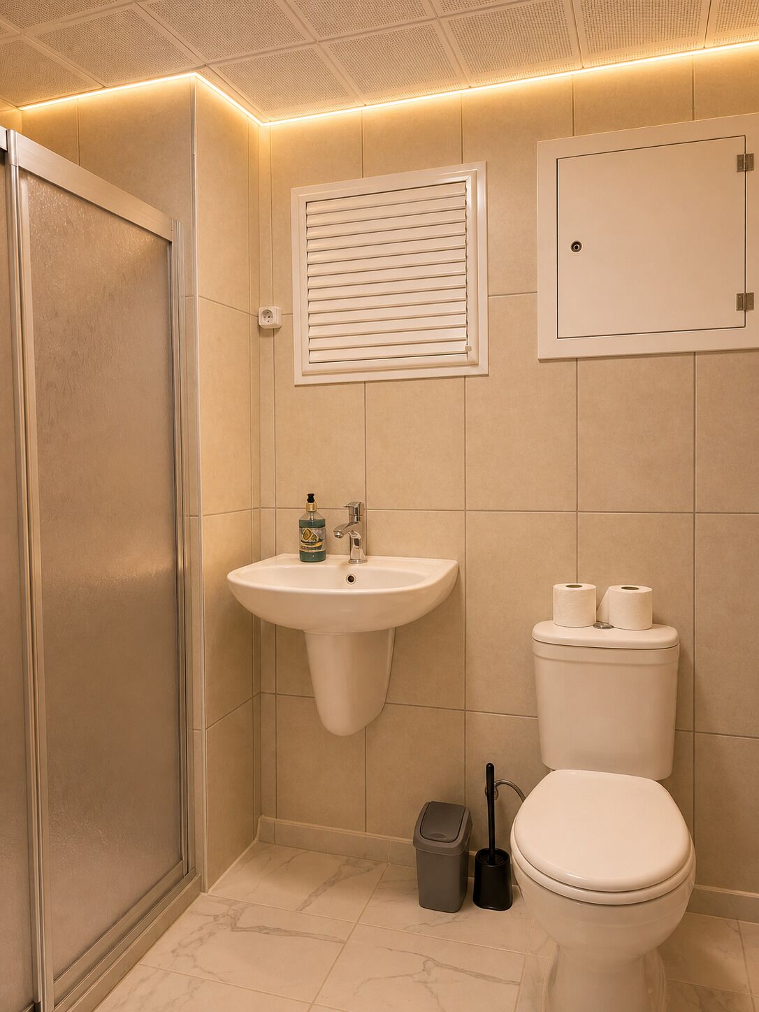 Un baño con inodoro, lavamanos y ducha.