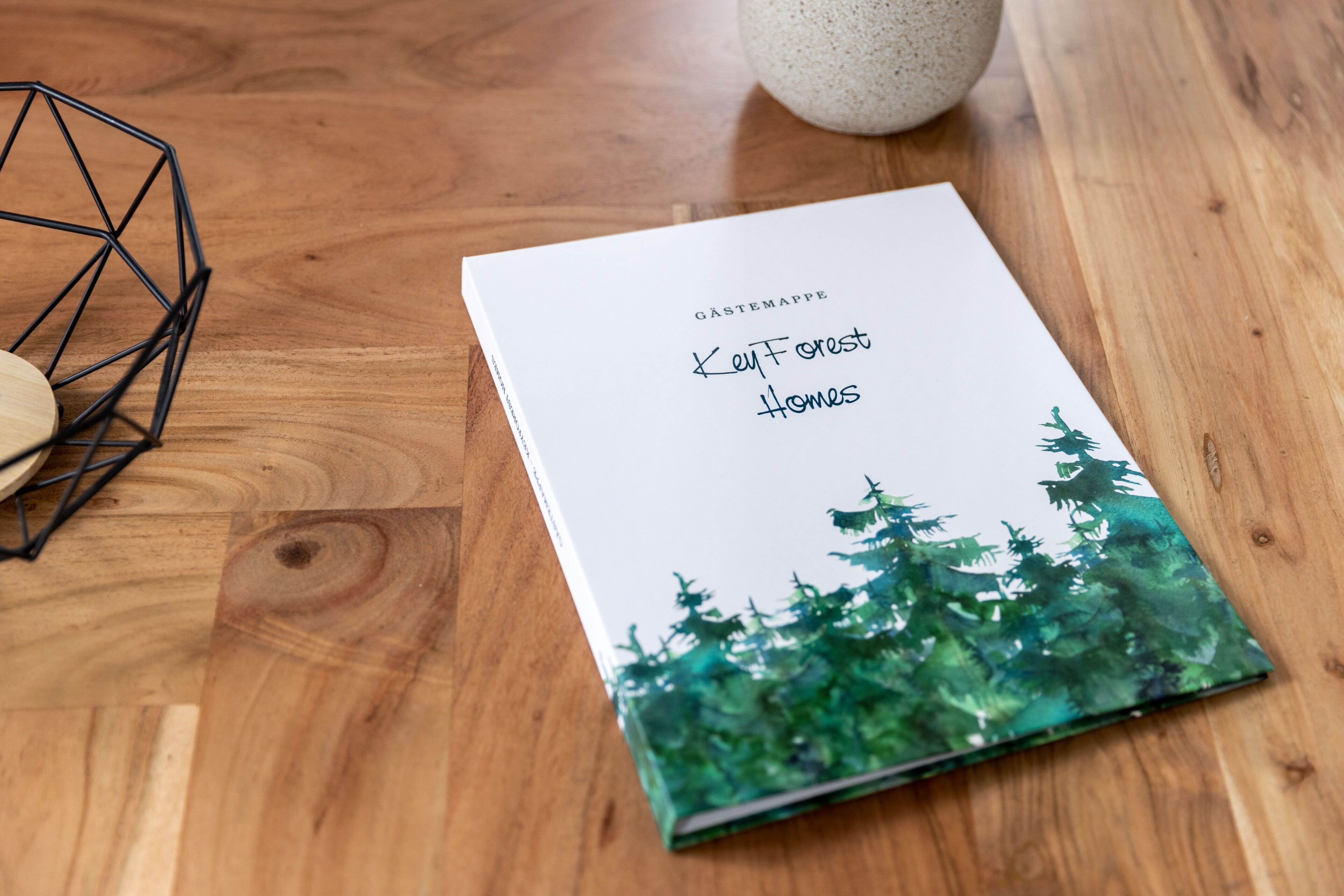 A book titled 'Key Forest Homes' on a wooden table.