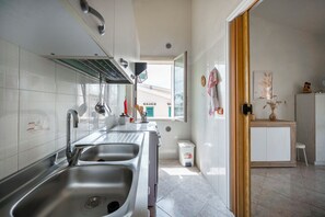 A modern kitchen with stainless steel appliances, a double sink, and a view to the outside. - Apartment Elvira sea view (Avola)