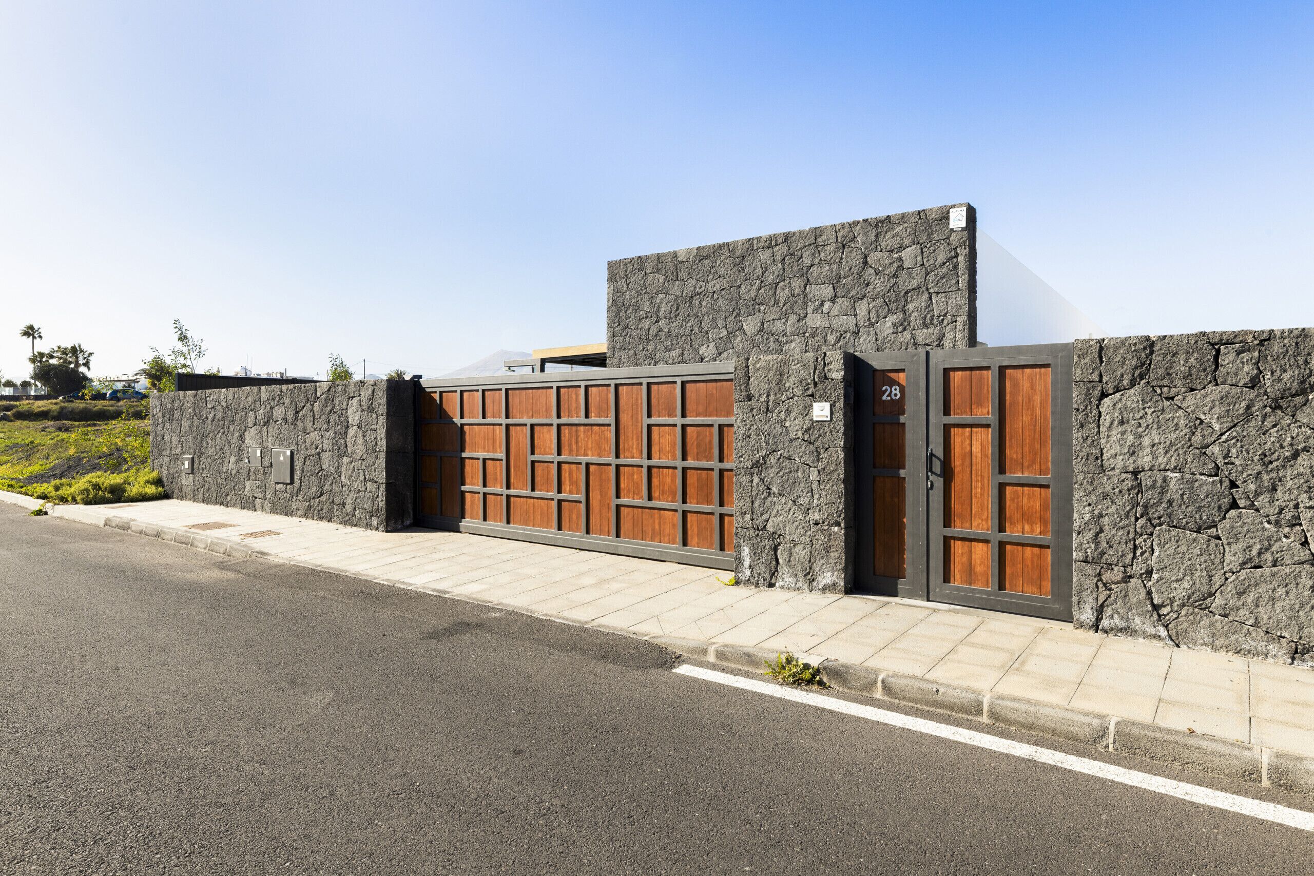 Um edifício moderno com fachada de pedra e portas de madeira, com uma placa com o número do endereço.
