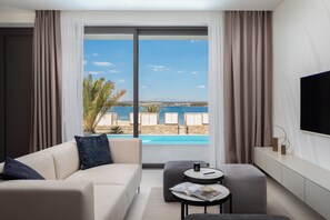 A modern hotel room with a large window offering a view of a pool and beach. - The Palms Resort Villa Beach Five with Pool (Tkon)
