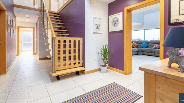 A modern interior with a staircase, a living area with a sofa, and a dining area with a lamp. - Cosy independent studio in a small village with countryside views (Richhill)