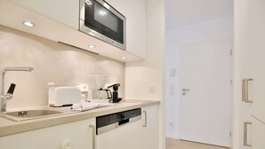 Uma cozinha moderna equipada com máquina de lavar louça embutida, micro-ondas e cafeteira.