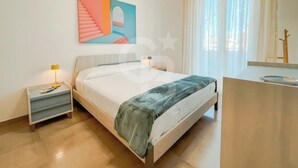 Un dormitorio moderno con cama, mesita de noche y escritorio.