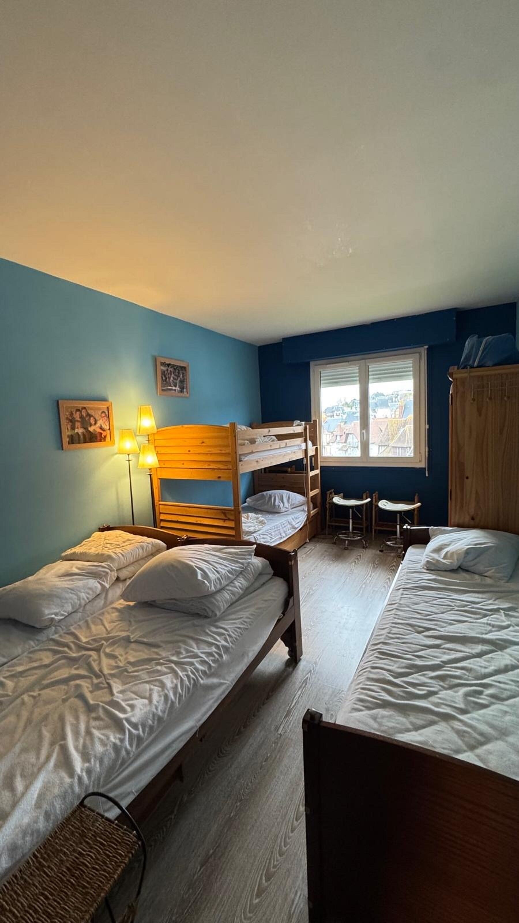 Ein Schlafsaalzimmer mit Etagenbetten, einem Schreibtisch und einem Fenster mit Blick.