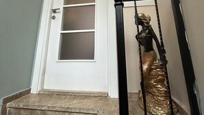 A staircase with a black handrail and a golden statue of a mermaid. - Bohemian Antique House in Colorful Balat (İstanbul)