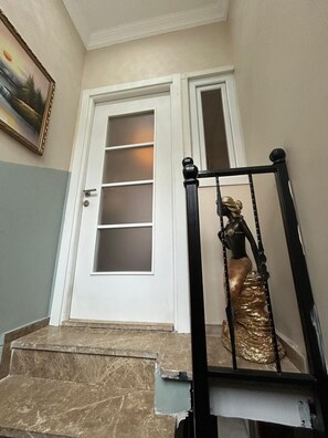 A staircase with a black handrail and a golden statue of a mermaid. - Bohemian Antique House in Colorful Balat (İstanbul)