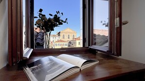 A window with a view of a building with a dome and a book on a wooden ledge.