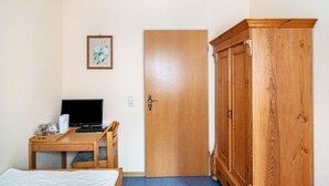 A room with a bed, a desk with a laptop, a wooden wardrobe, and a door. - Room 'Einzelzimmer 4' with Mountain View, Shared Terrace and Wi-Fi (Bernkastel-Kues)