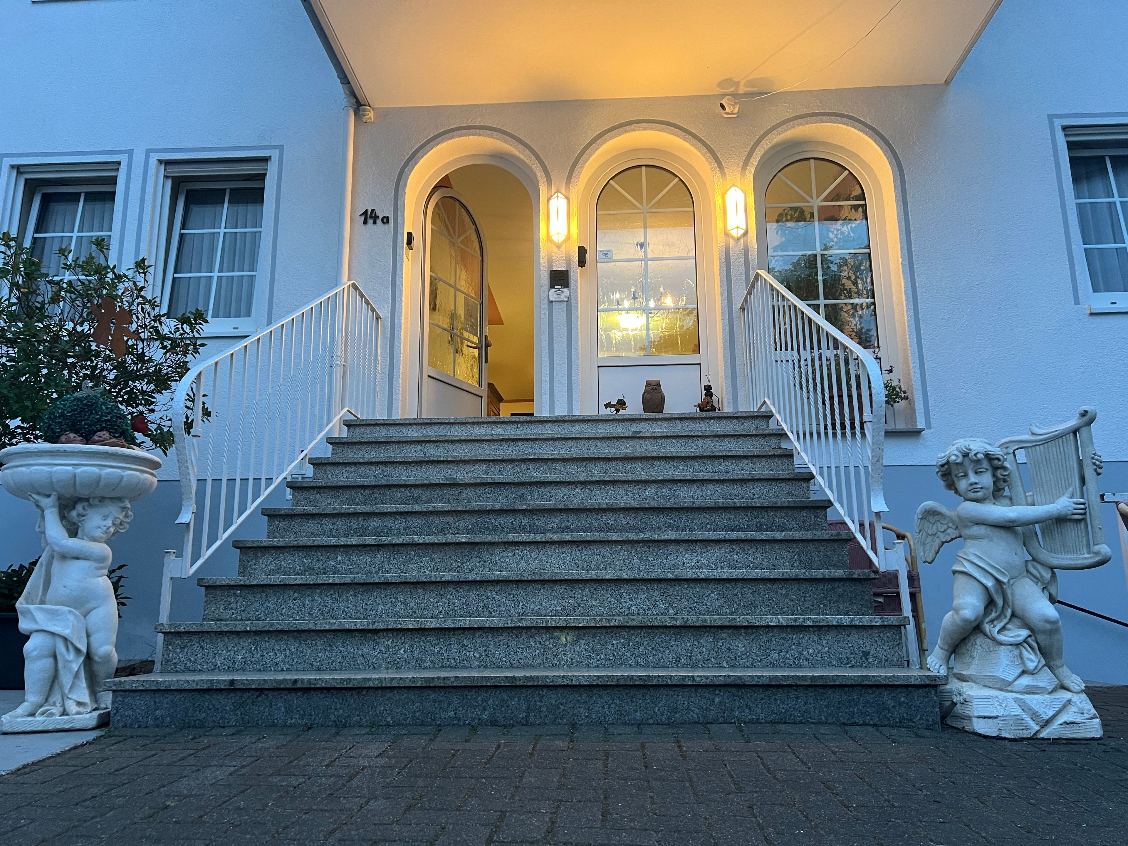 Une entrée d’immeuble avec un escalier, une porte et une boîte aux lettres.