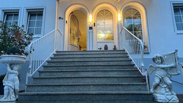 A building entrance with a staircase, a door, and a mailbox.