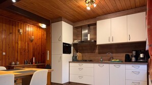 Una cucina moderna con pannelli in legno, pensili bianchi, un forno a microonde e un lavello.