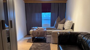 Un soggiorno moderno con un divano, un lettino da massaggio e una poltrona in pelle.