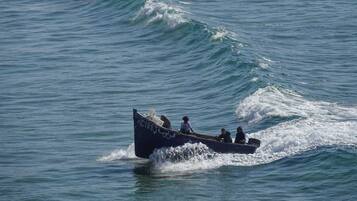 A small boat with several people on it, moving through the water.