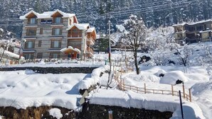 Un hotel de varios pisos con fachada de piedra, balcones y un letrero que dice "The Montang Chalet".