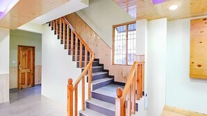 Una escalera con barandillas de madera y piso de color claro.