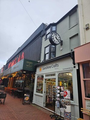 Ein Schaufenster mit einer Uhr, einem Schild für Sunshine Crafts und einem Schild für ein Café.