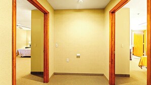 Pasillo de hotel con pisos alfombrados, molduras de madera y pared lisa.