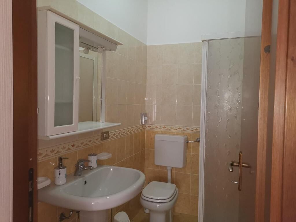 Un baño con lavamanos, inodoro y ducha.