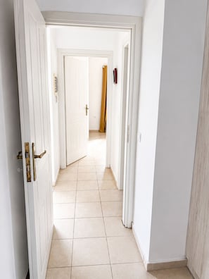 A hallway with white doors, a tiled floor, and a view into another room. - Sea to Summit Terrace 2BD 1BA 7mn to Georgioupoli (Apokoronas)