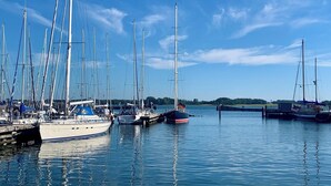 A marina with multiple sailboats docked at the pier. - Linda - Balcony with sea view, private beach chair on the beach, swimming pool (Kronsgaard)