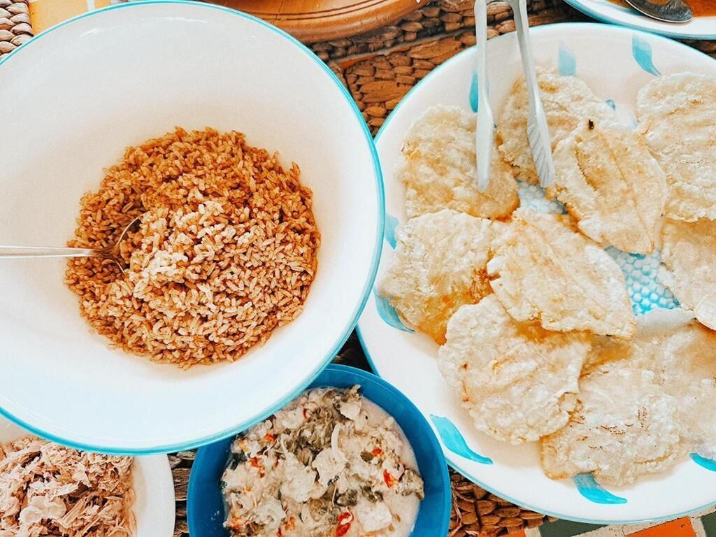 A table with various dishes including rice, fried items, and a creamy dish.
