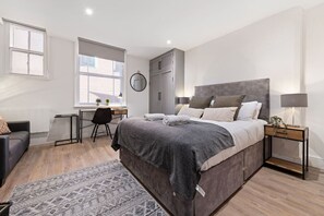 A modern bedroom with a large bed, a desk, and a chair. - Comfortable 1 Bed Studio, 10/10 Location (Nottingham)