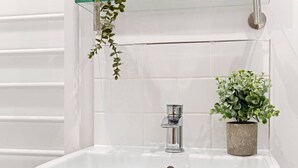A bathroom with a white sink, a chrome faucet, and a potted plant. - Comfortable 1 Bed Studio, 10/10 Location (Nottingham)