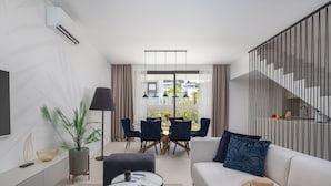 A modern living room with a sofa, coffee table, and dining area. - The Palms Resort Villa Beach Six with Pool (Tkon)