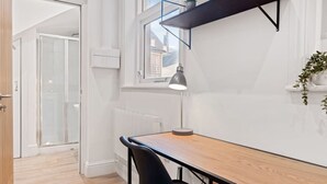 Uma cozinha moderna com uma mesa de madeira, cadeiras pretas, uma luminária pendente e uma janela com vista.