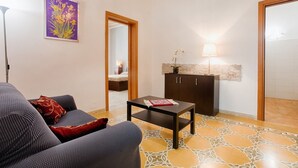 Ein Wohnzimmer mit einer Couch, einem Couchtisch, einem Schrank und einer Tür zu einem weiteren Raum.